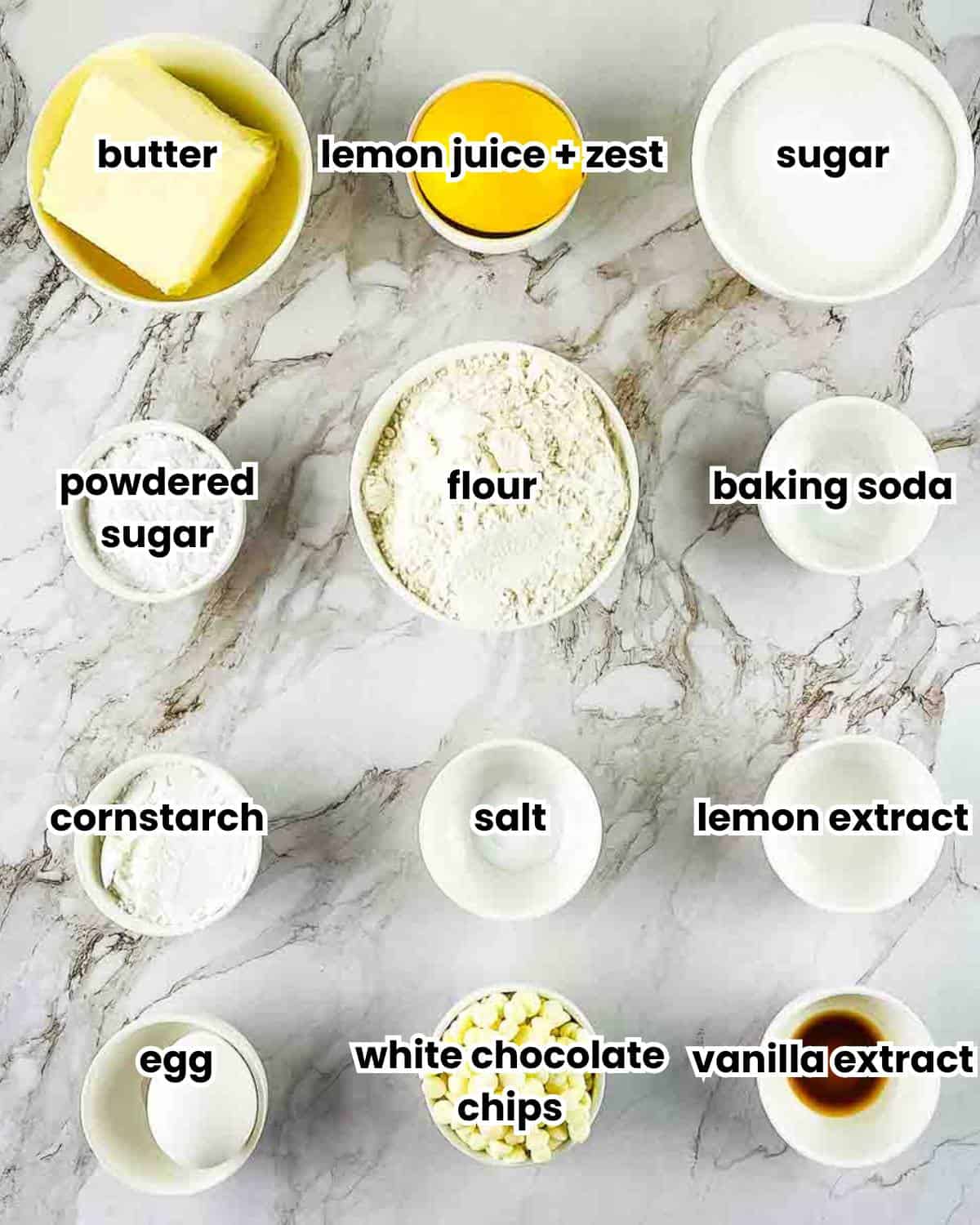 A photo showing the labeled ingredients for lemon drop cookies measured out on a white counter.