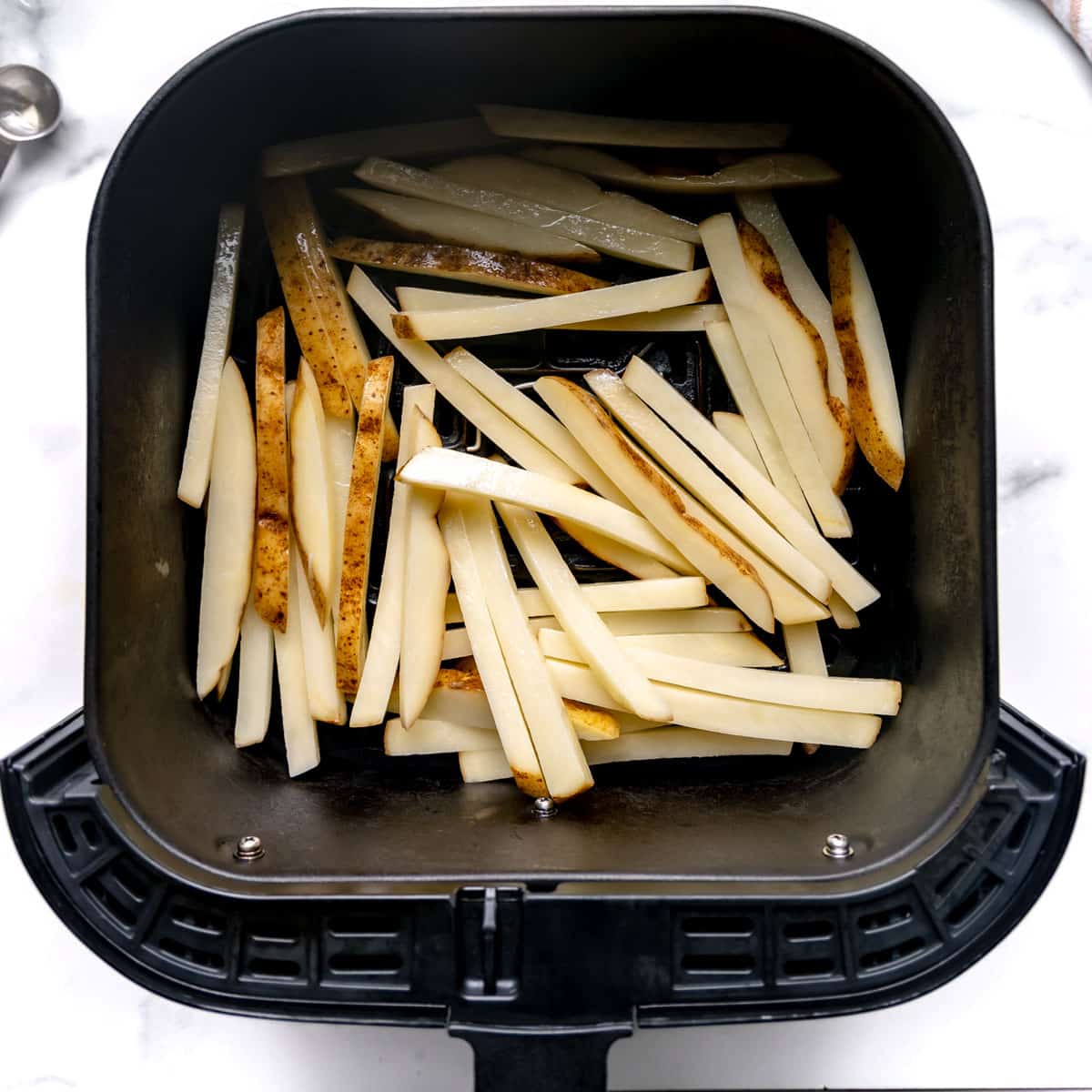 French fries in an air fryer basket.
