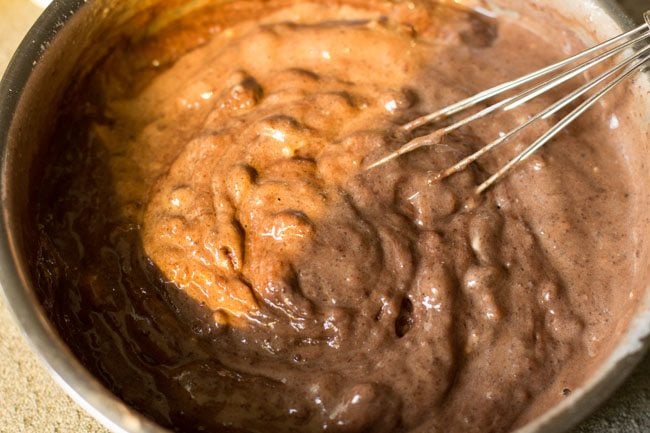 mixing curd mixture in chocolate-flour mixture with a whisk. 