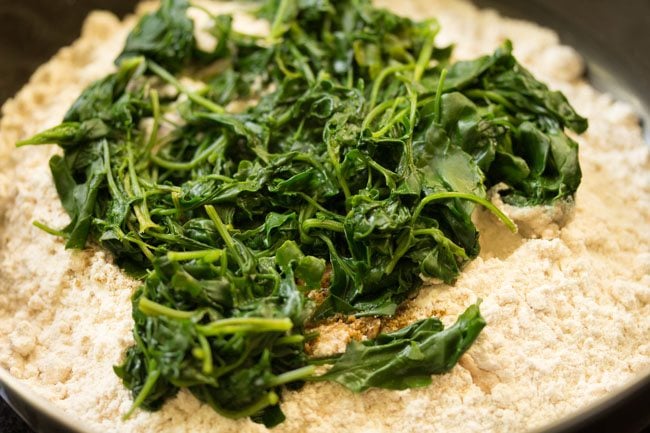 strained cooked bathua leaves added to flour mixture. 