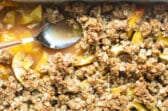 Peach Crisp in a baking dish with a spoon.