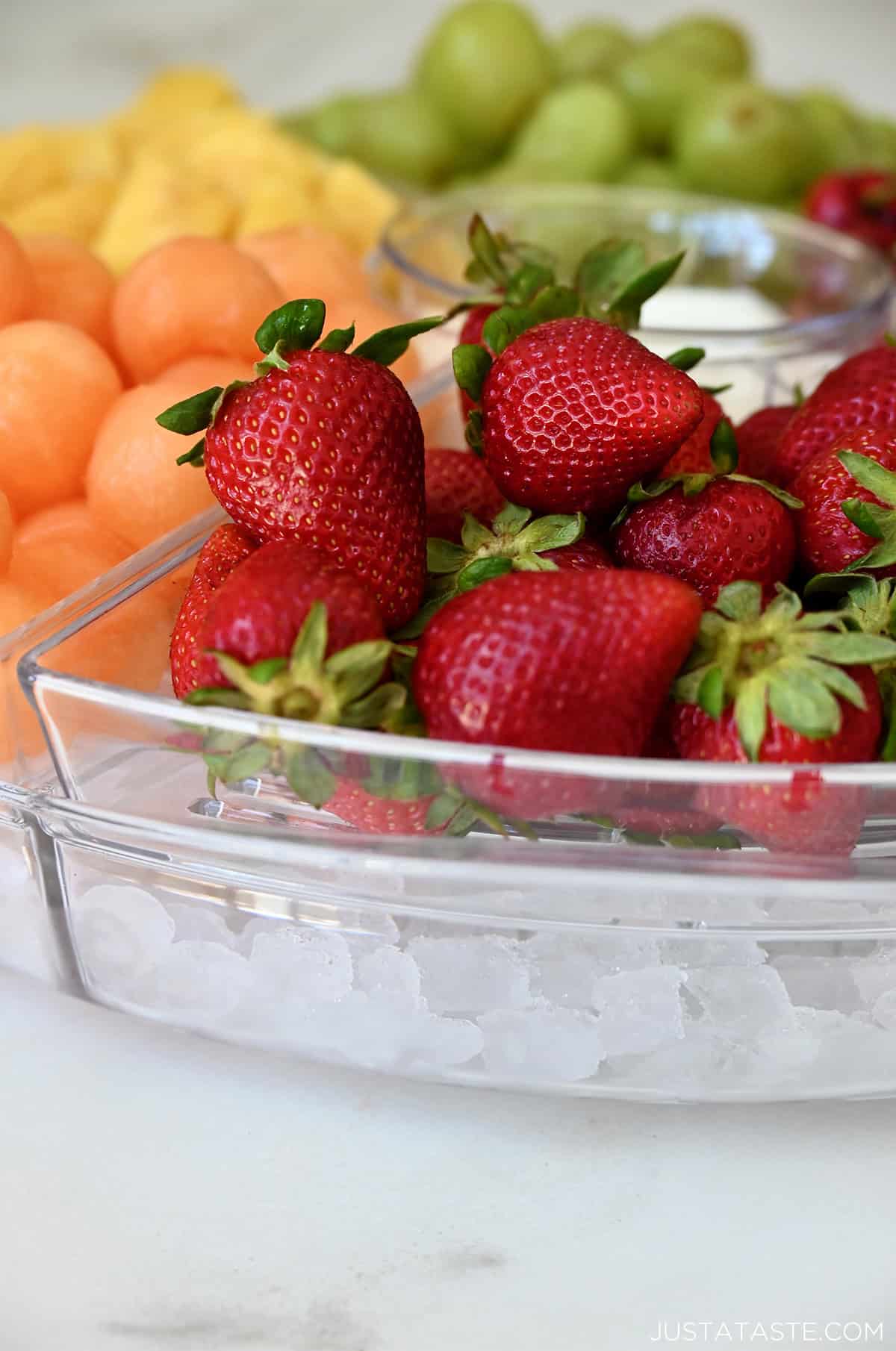 Fresh strawberries in a serving tray over ice.