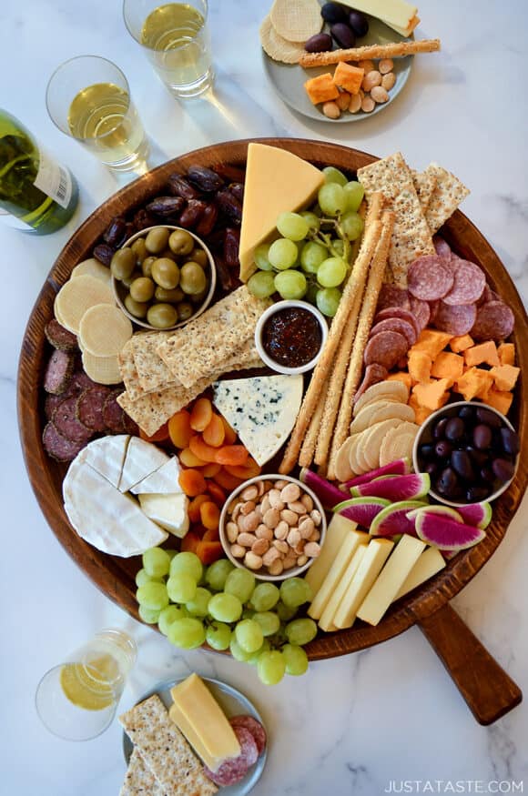 A top down view of a charcuterie board filled with meat, cheese, fruit and crackers